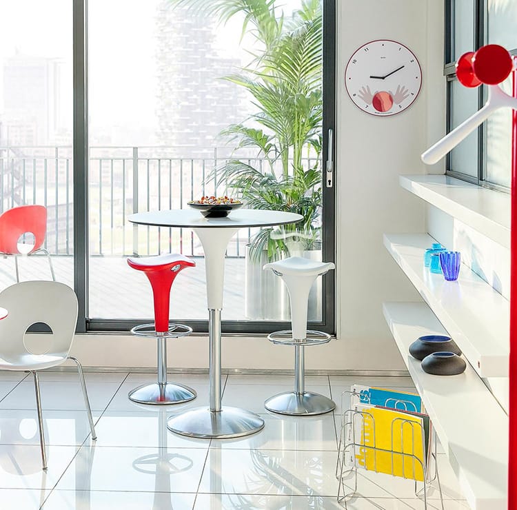 Modern interior featuring Clocks - Desk Accessories, with a round white clock, red accents, and sleek furniture.