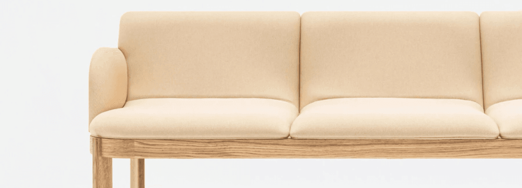 Beige Ramp Sofa with wood base. Modern seating for social and relaxed spaces.