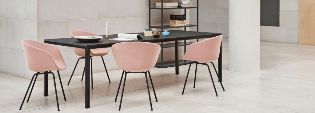 HAY AAC 27 chair in pink fabric with black steel legs around a black table.