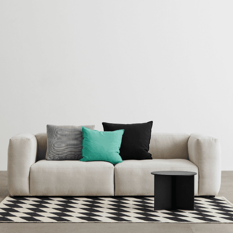 Beige Mags Soft Sofa with colorful pillows on a black and white rug, modern style.