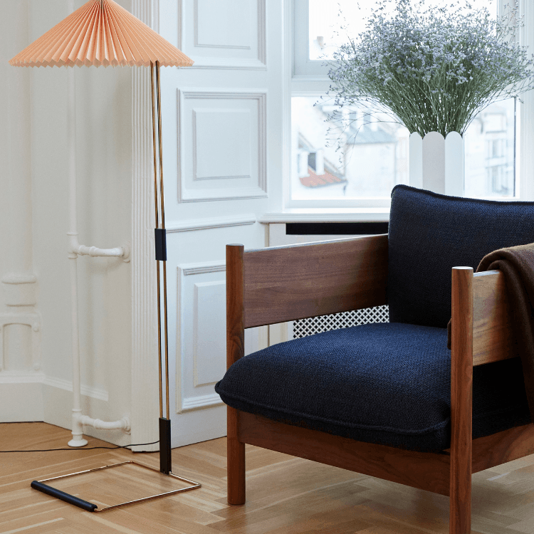Modern Arbour Sofa Collection armchair with wooden frame, blue cushions, and a stylish floor lamp.