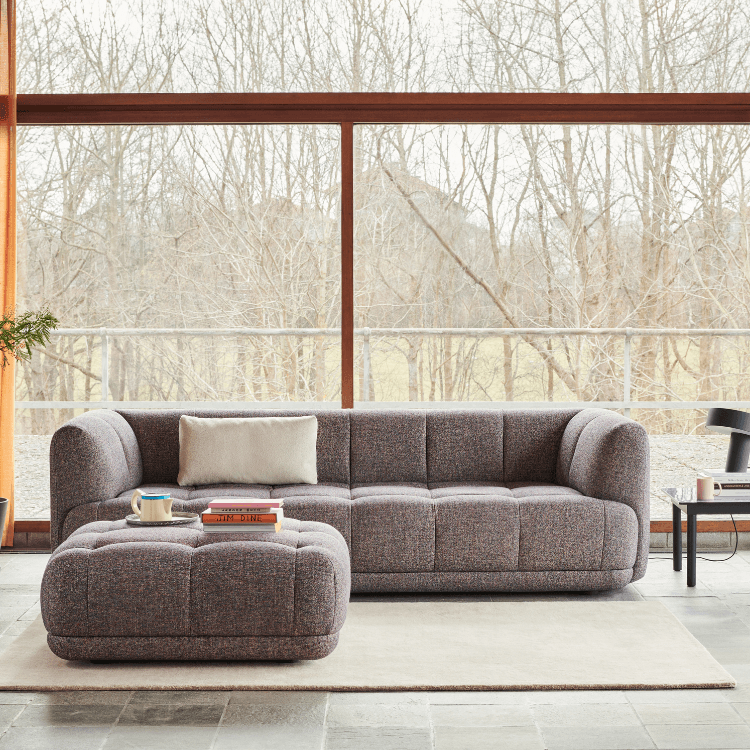 HAY QUILTON Sofa with ottoman. Modular seating in textured gray fabric. Modern living room interior.