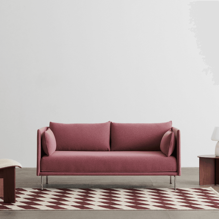 Front view of a modern Silhouette Sofa in rose fabric with steel legs.