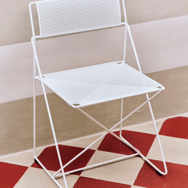 White X-Line Chair with perforated seat and back. Modern, minimalist style.