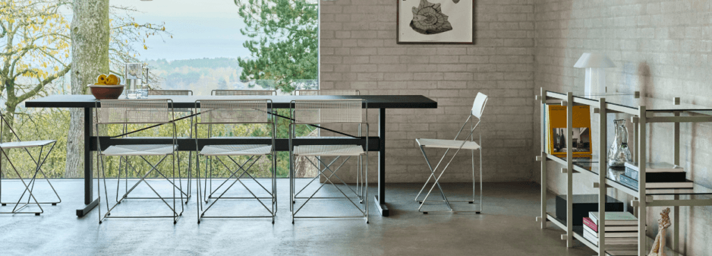 Minimalist dining area with X-Line Chair. Woven seat, metal frame. Modern design for home or office.