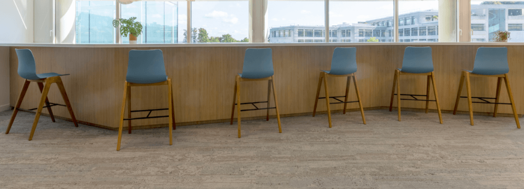 Row of Polly Wood Stool chairs in blue with wood legs, bar-height seating.