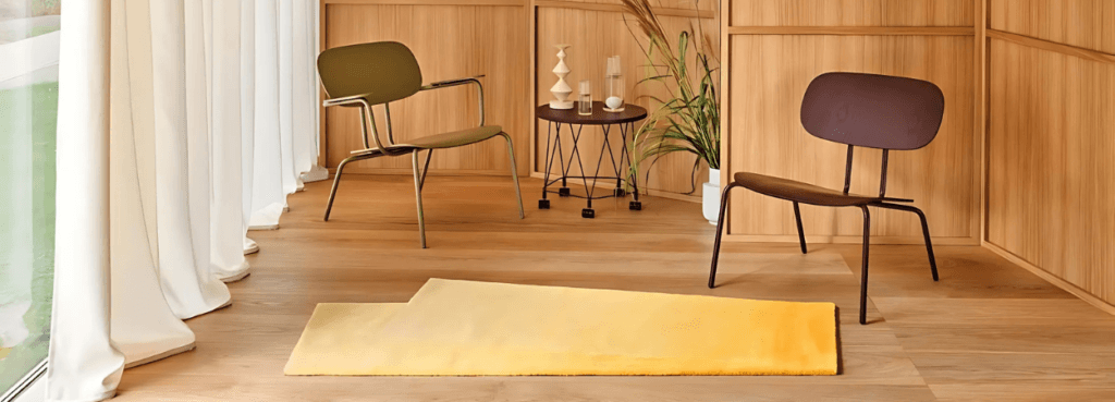 Modern interior with New School Lounge Plywood Armchair in green and brown, plus yellow rug.