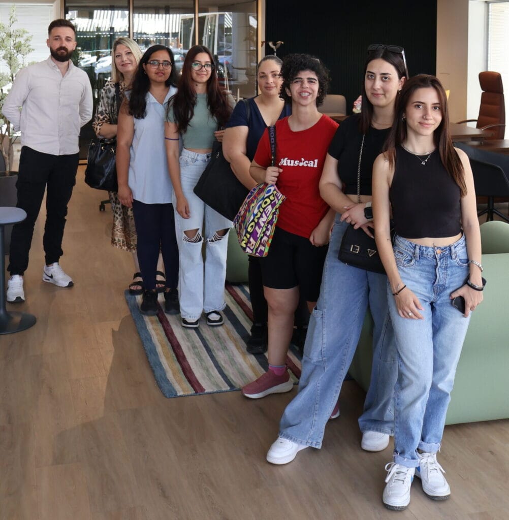 Cyprus College students visit a studio office. Group of young people standing indoors.