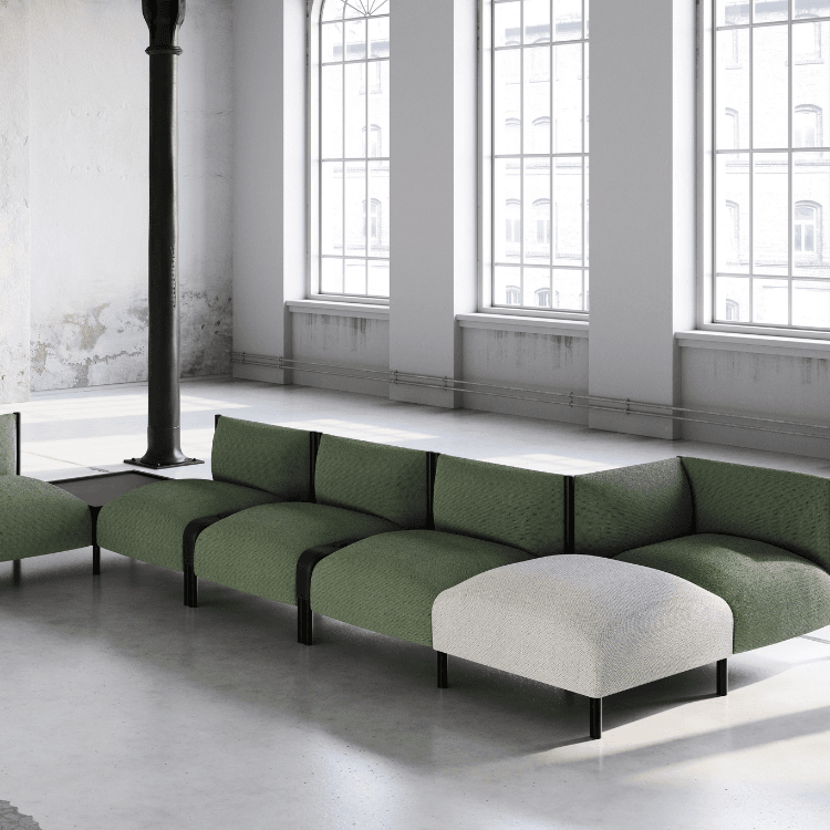 Modern WAFFLE Endless modular seating system in green fabric with a white ottoman in a bright, industrial-style space.