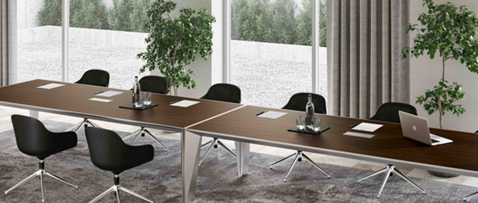 Sustainable Office Design: Eco-friendly furniture in a modern conference room with a long table, black chairs, and plants.