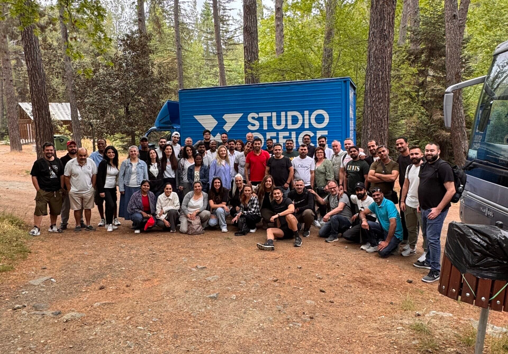 Company Day Trip 2025: Group photo of Studio Office employees outdoors with a company truck and bus.