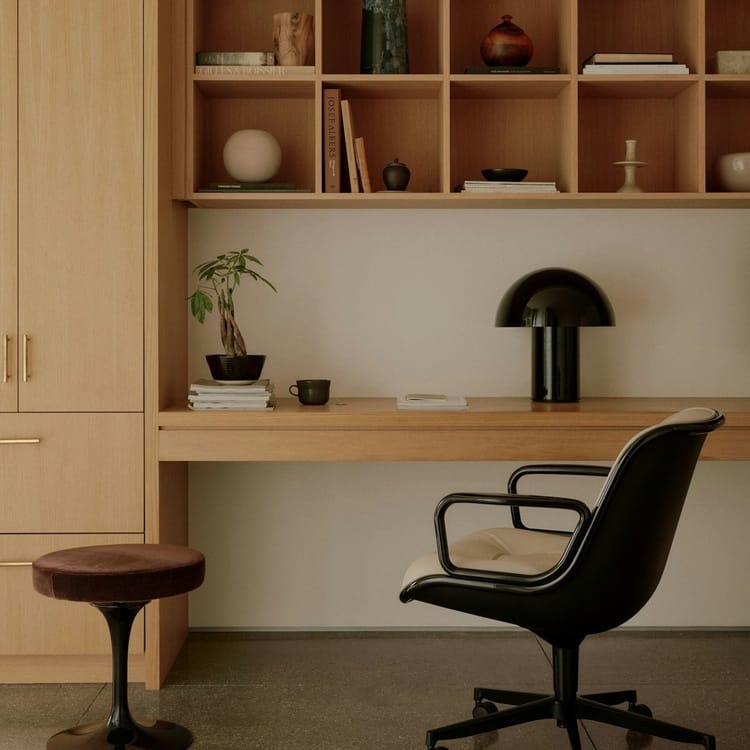 Modern office with black Pollock Executive Chair, light wood desk, and brown stool.