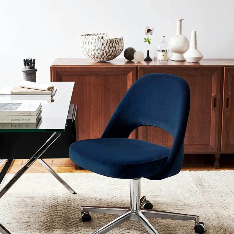 Angled view of a blue Saarinen Chair Armless with Swivel Base. The chair has a metal base and is on a beige rug.