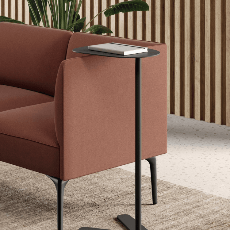AUTO-DRAFT table in black, paired with a rust-colored sofa. Modern design for functional style.