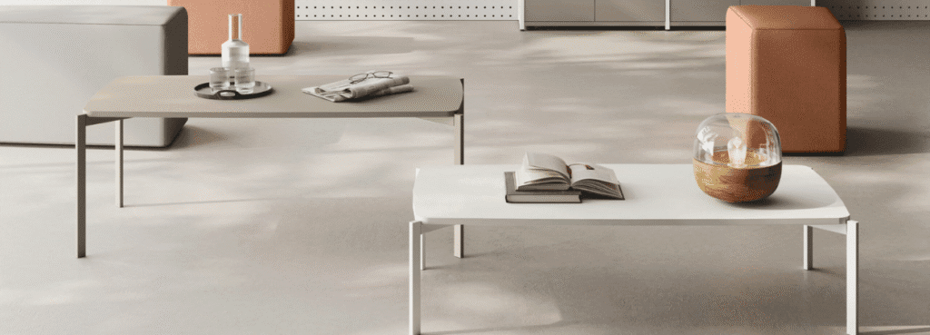 Modern AUTO-DRAFT coffee tables. One is gray with a newspaper, the other is white with a book and decorative lamp.