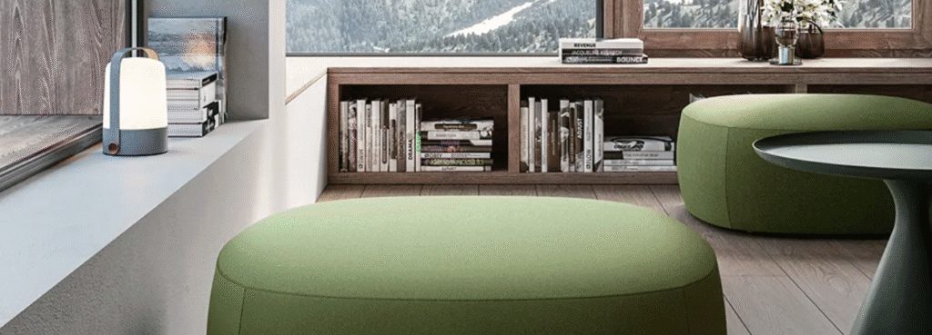 Modern living room with green AUTO-DRAFT ottomans, table, and a lamp by the window.