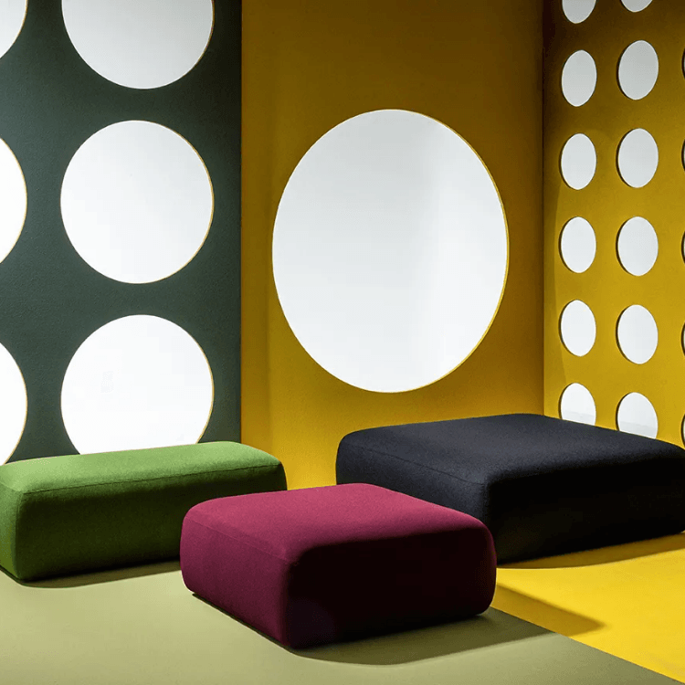 Colorful AUTO-DRAFT ottomans in green, red, and black. Modern, geometric design with round wall accents.