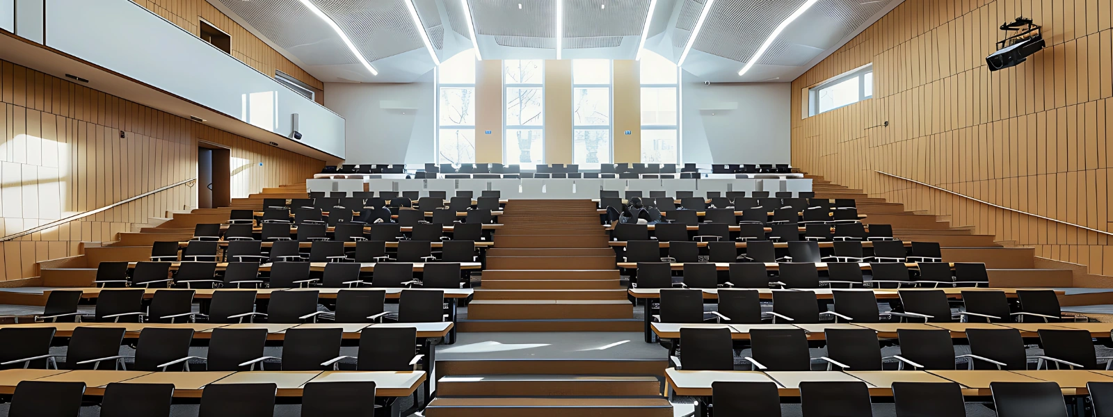Modern collaborative lecture hall design featuring tiered seating, ample natural light, and a spacious layout for university students.