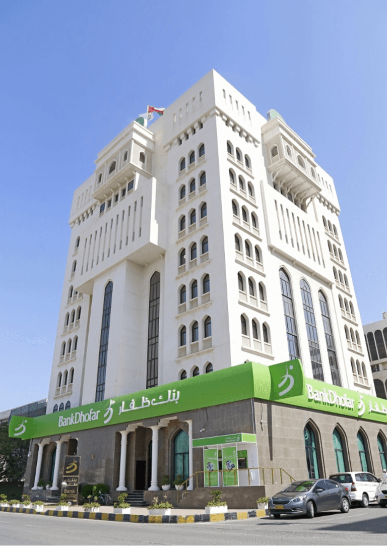 Bank Dhofar building in Muscat, Oman. Modern architecture with green signage. Bank-Dhofar.png