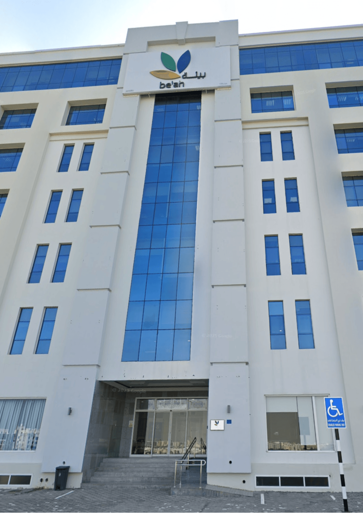 Oman Environmental Services building in Muscat, Oman. Modern architecture with blue glass and the 'be'ah' logo.