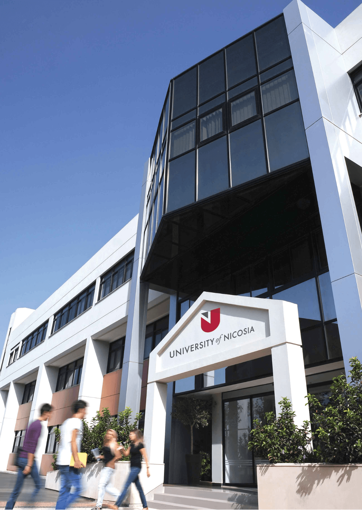 University of Nicosia building exterior with students walking by, showcasing the campus environment and modern architecture.