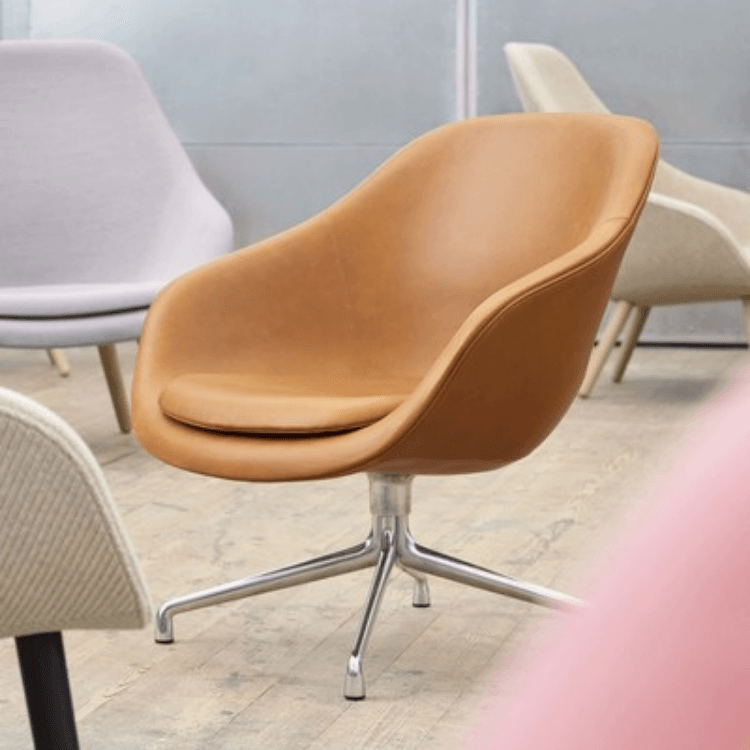 A tan leather AAL 81 lounge chair with a sleek swivel base, shown in a modern interior setting.