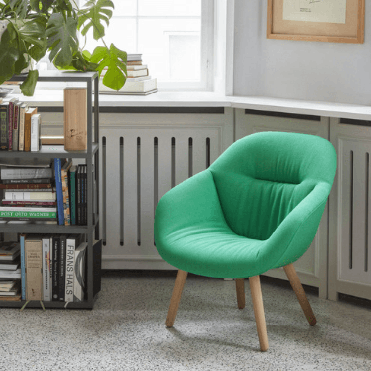 AAL 82 Soft chair in bright green upholstery with a quilted front and light oak legs in a cozy interior setting.