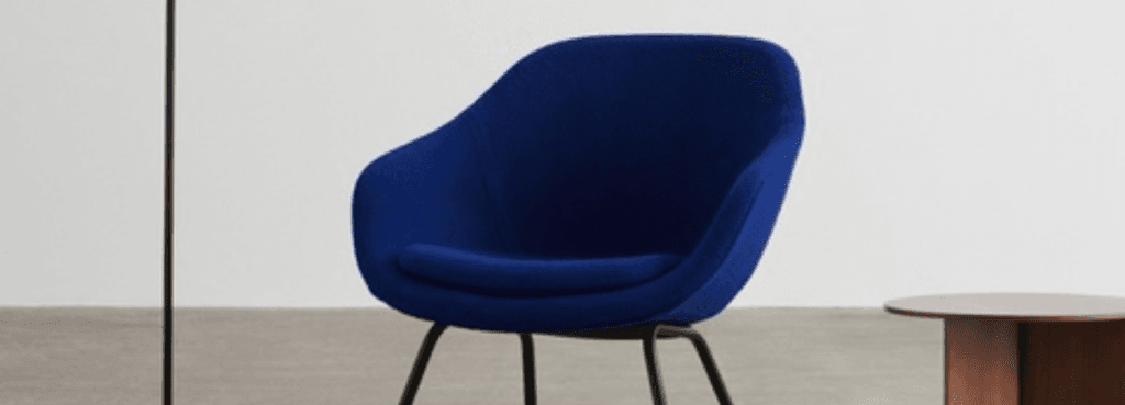 Vibrant cobalt blue AAL 87 lounge chair with a rounded, plush seat shell perched on thin, matte black metal legs.