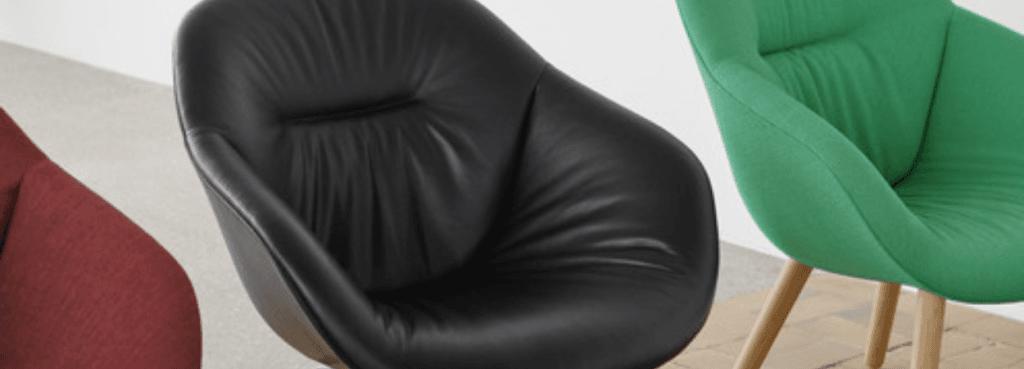 AAL 87 Soft chairs in black leather and vibrant green fabric, showcasing their quilted shell design and wide silhouettes.