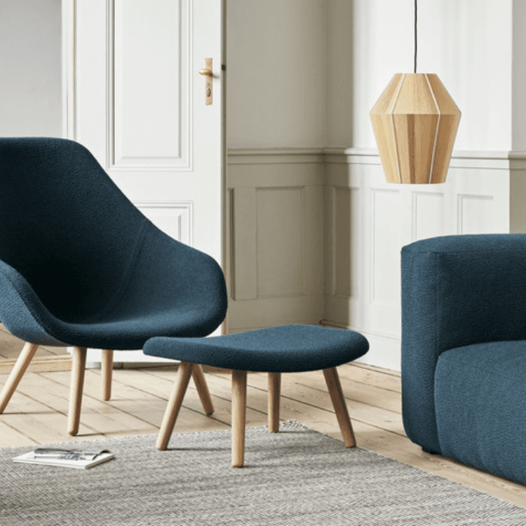 Deep blue AAL 93 lounge chair with textured upholstery and natural oak legs in a bright interior living space.
