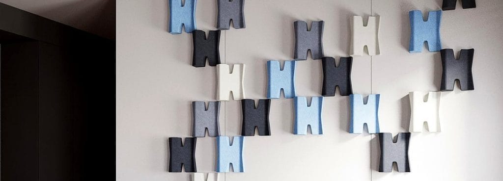 Arbor Weave PET felt modules in dark and light tones create a modular geometric wall installation with negative space.