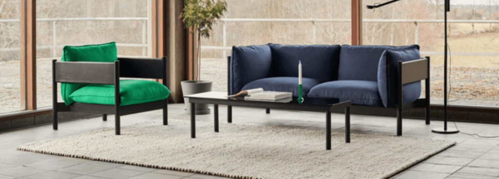 Bright green Arbour Club Armchair paired with a dark blue sofa in a sunlit interior with tiled flooring.