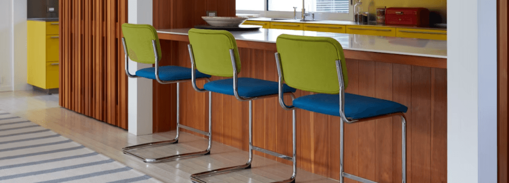 Trio of Cesca Stool designs with chrome cantilever bases, vibrant blue seats, and bright lime green backrests.