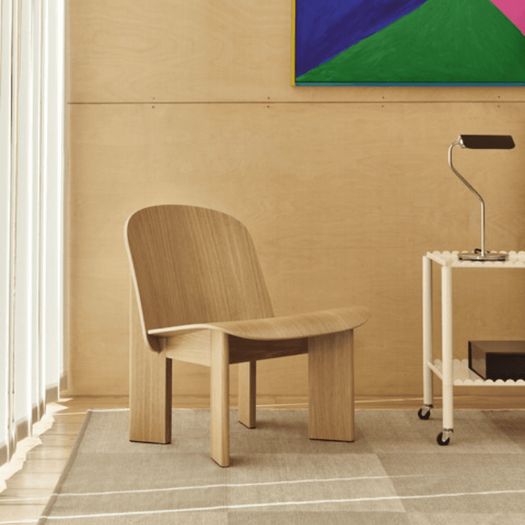 Chisel 85 Lounge Chair in solid wood with distinctive bevelled legs, showcased in a modern room setting.