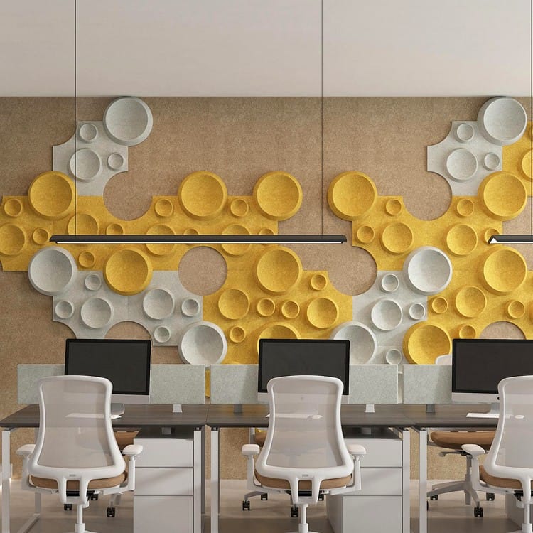 Modular Crater Max felt tiles featuring organic circular patterns in yellow and grey installed on a modern office wall.