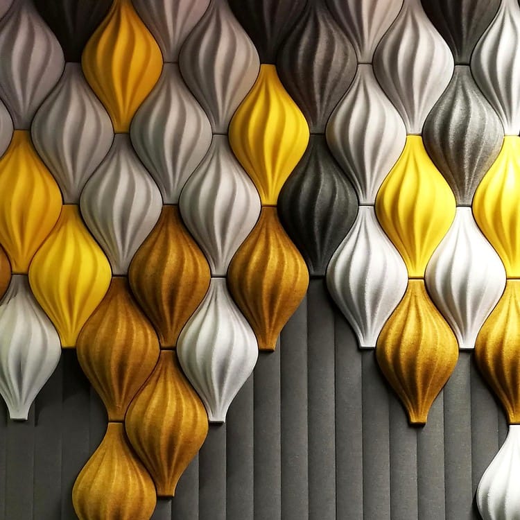 Modular Feather Flow acoustic components in vibrant yellow, gold, and grey felt forming a dynamic 3D wave pattern.
