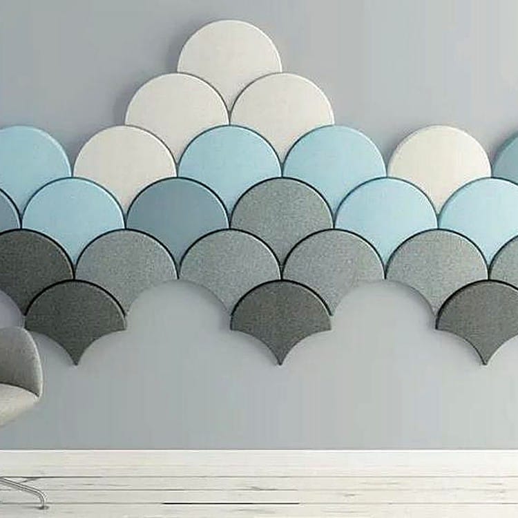 Ginkgo Flow acoustic wall tiles arranged in a gradient of grey to blue tones creating a soft, scalloped leaf design.