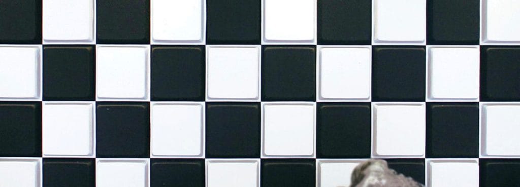 Key Grid 3D acoustic panel with a black and white checkerboard pattern of raised felt squares for sound absorption.