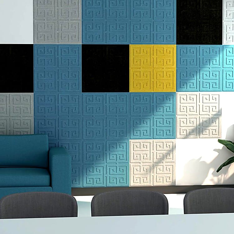 Labyrinth acoustic wall panels in a multi-colored grid layout made from soft felt with recessed Greek-key designs.