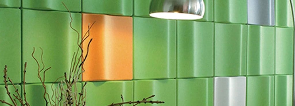 Litho Glow 3D acoustic panels in vibrant green and orange with a folded-paper crease design on a contemporary wall.