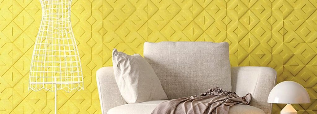 Bright yellow Love Script acoustic wall tiles with a structured diamond-and-chevron art-deco embossed pattern.