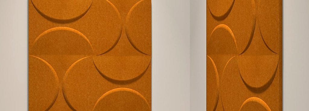 Lunar Crescent Big acoustic wall panels in warm orange PET felt with embossed circle and crescent geometric patterns.