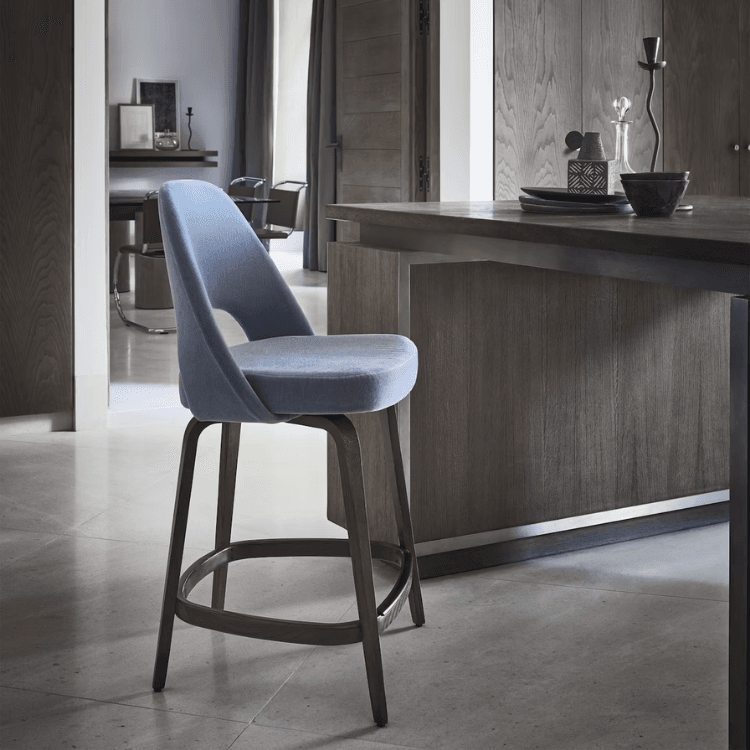Saarinen Executive Stool with light blue upholstered seat and dark wood legs in a modern interior setting.