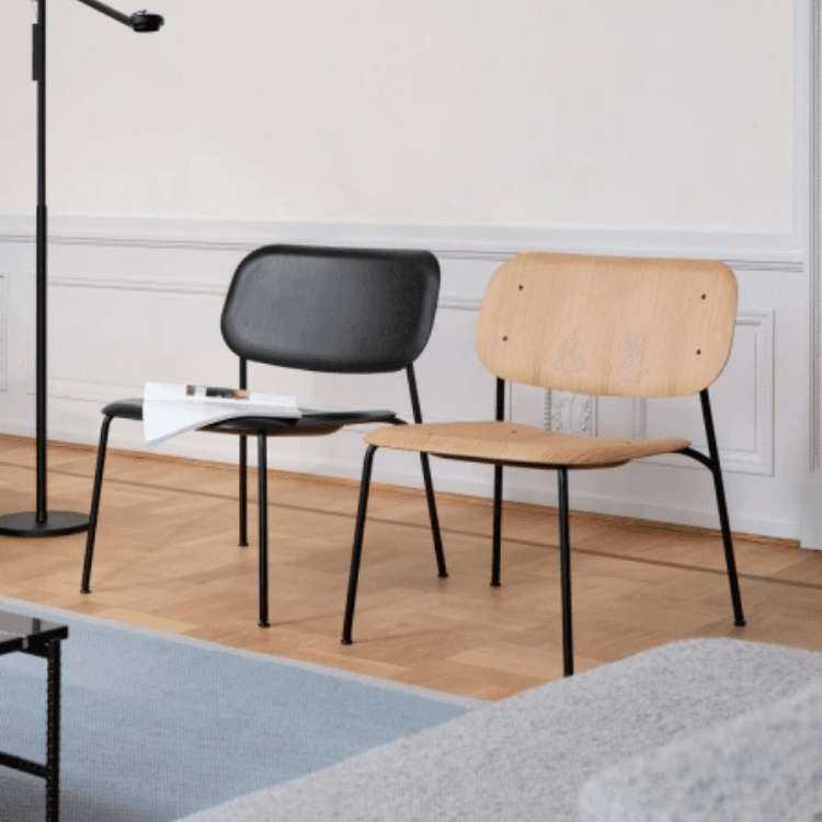 Two Soft Edge 100 lounge chairs with organic plywood shells and sleek black steel bases in a modern interior setting.