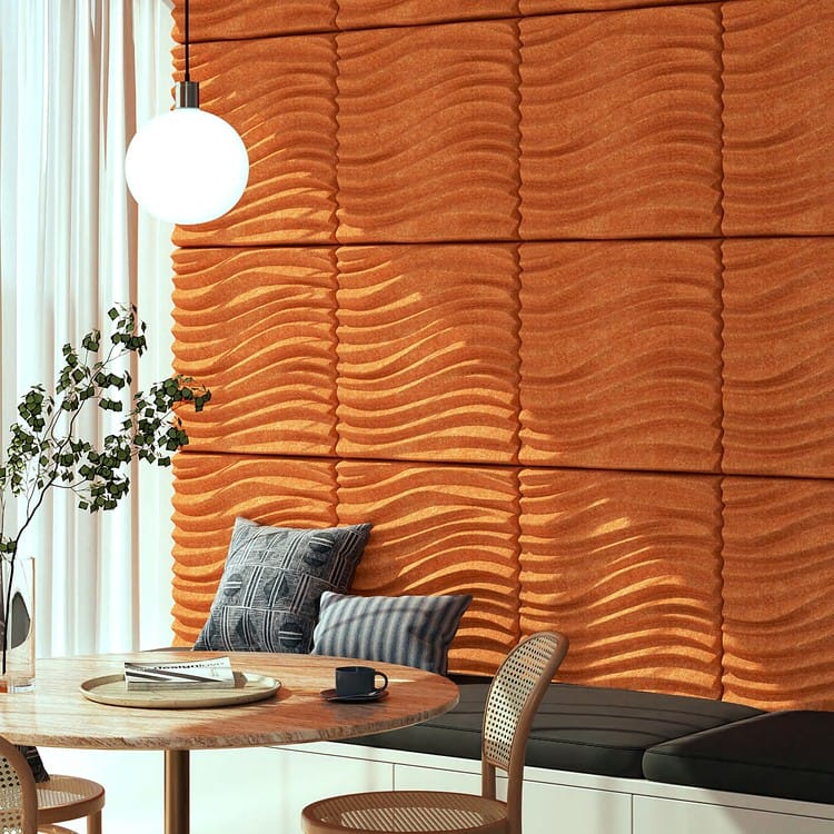 Vibrant orange Storm Wave acoustic wall panels with 3D undulating textures creating a bold, contemporary design feature.