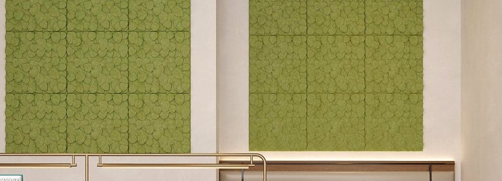 Verdant Shade acoustic wall panels featuring overlapping green leaf patterns in textured PET felt.