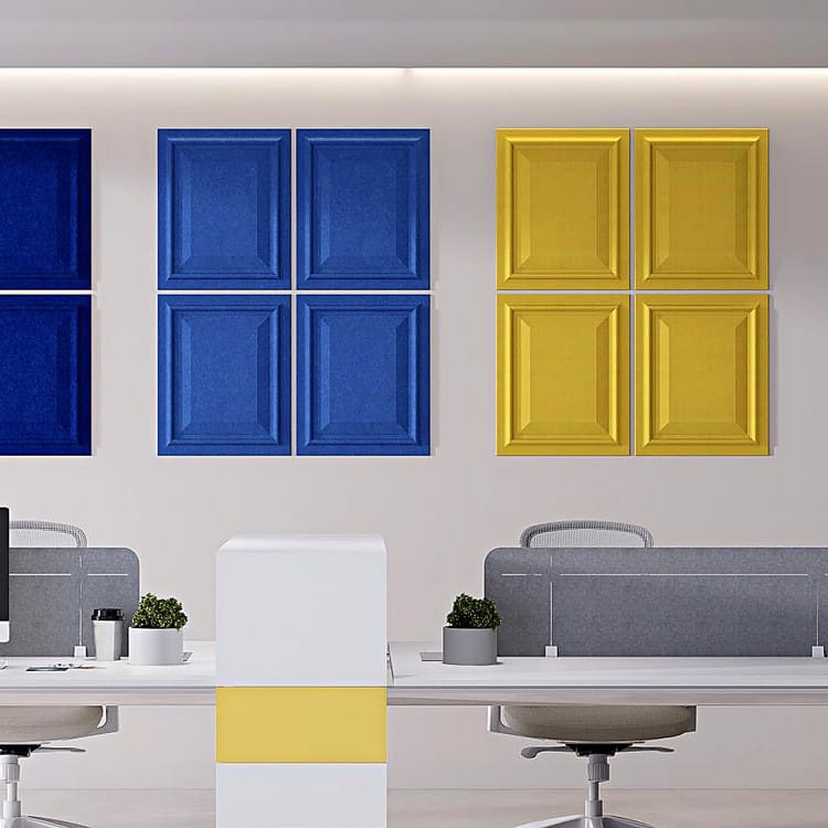 Wall Guard acoustic panels showing a grid of blue and yellow raised-panel PET felt tiles mounted on a white office wall.