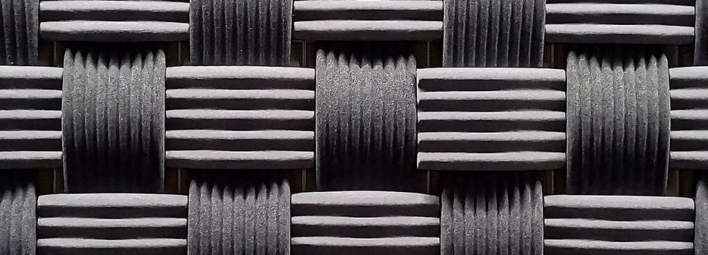 Close-up of Weave 3D acoustic panel in dark grey ribbed PET felt with an over-and-under basket weave design.